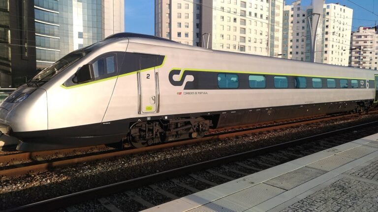 White and red high-speed tilting train at a station platform.
