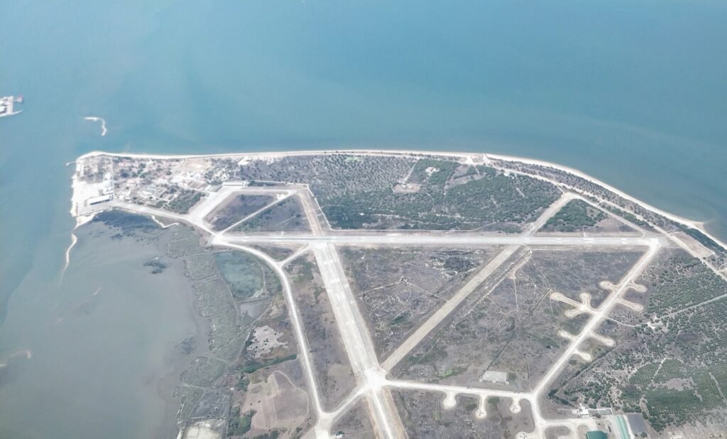 Aerial view of a military airfield with crossing runways on a peninsula surrounded by water.